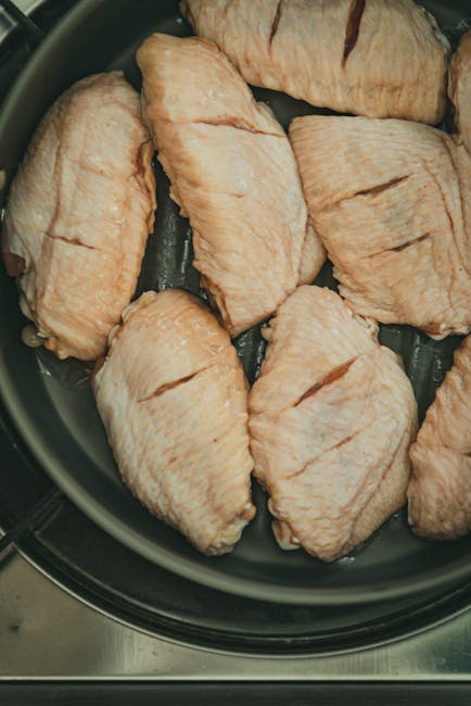 Close-up of raw chicken thighs arranged in a frying pan, ready for cooking preparation.