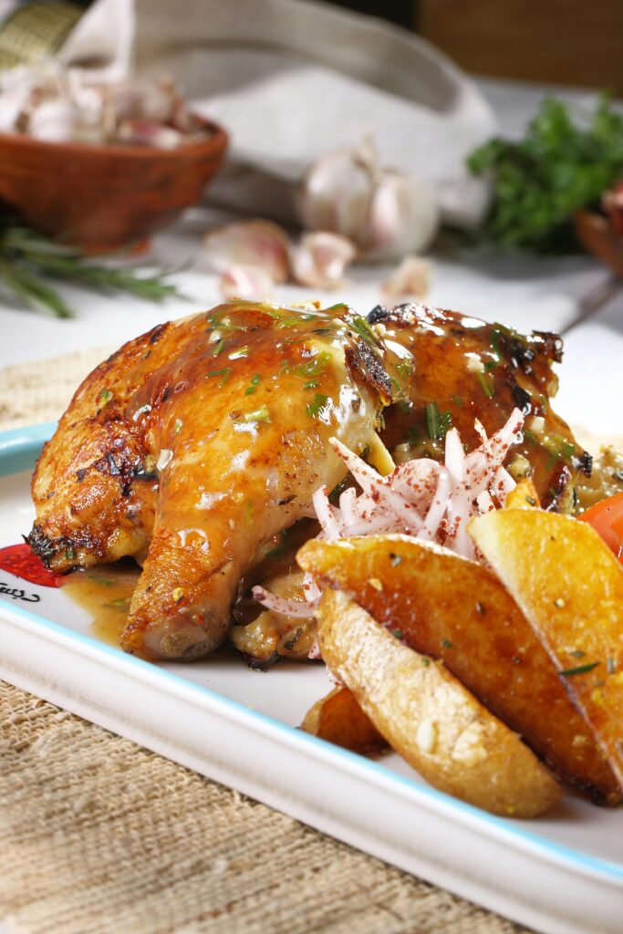 Delicious roasted chicken paired with golden potatoes and fresh herbs on a rustic platter.