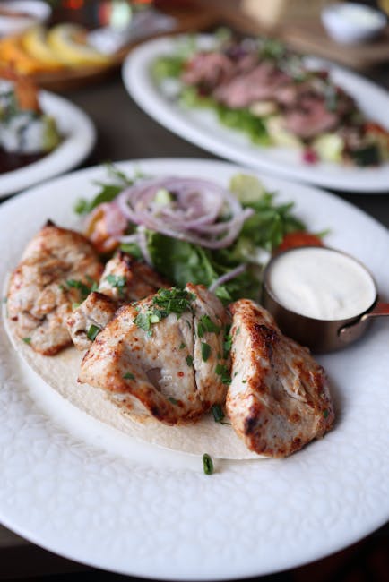 Delicious grilled chicken served with fresh salad and creamy sauce.